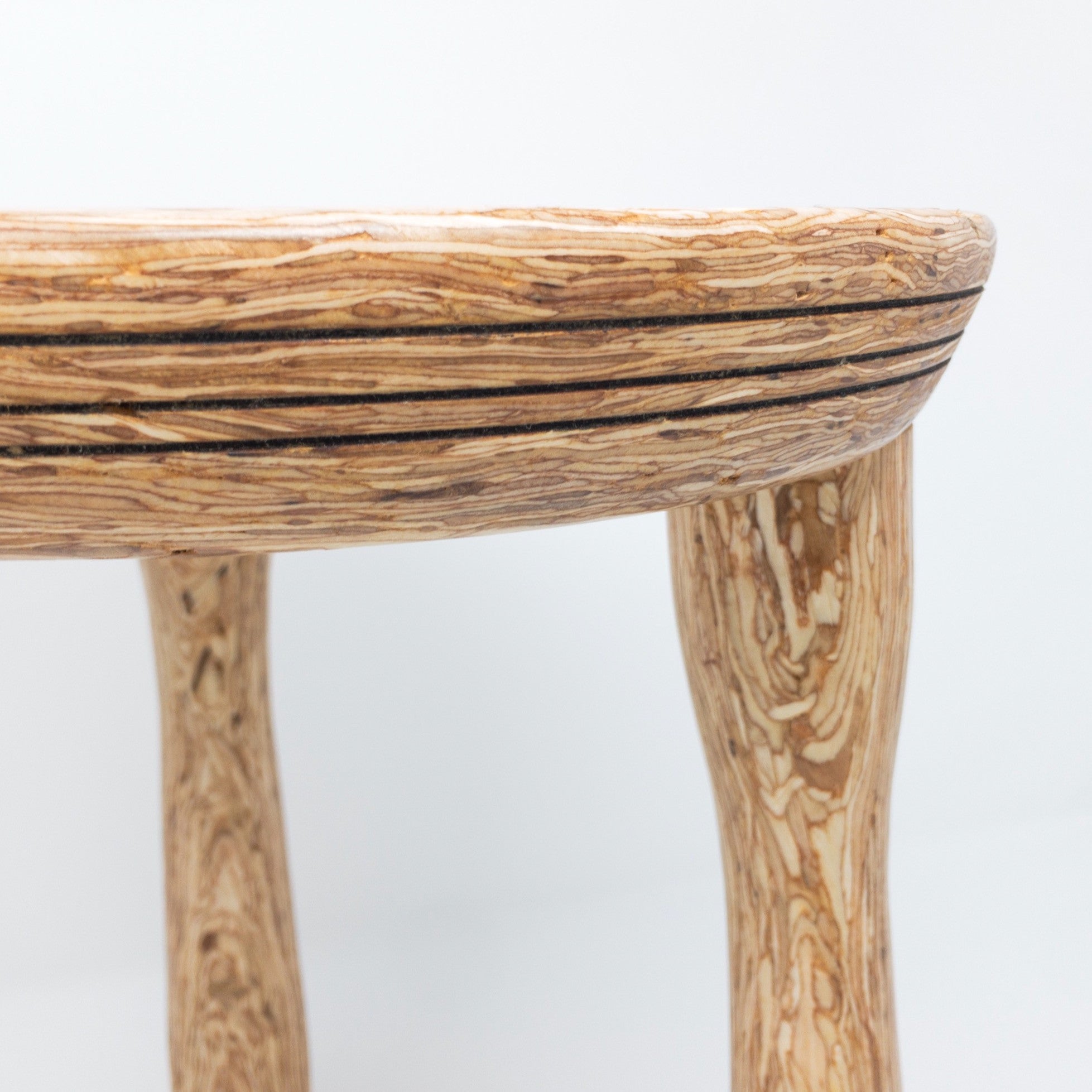 Three legged stool made of Parlam wood. Visually delightful.
